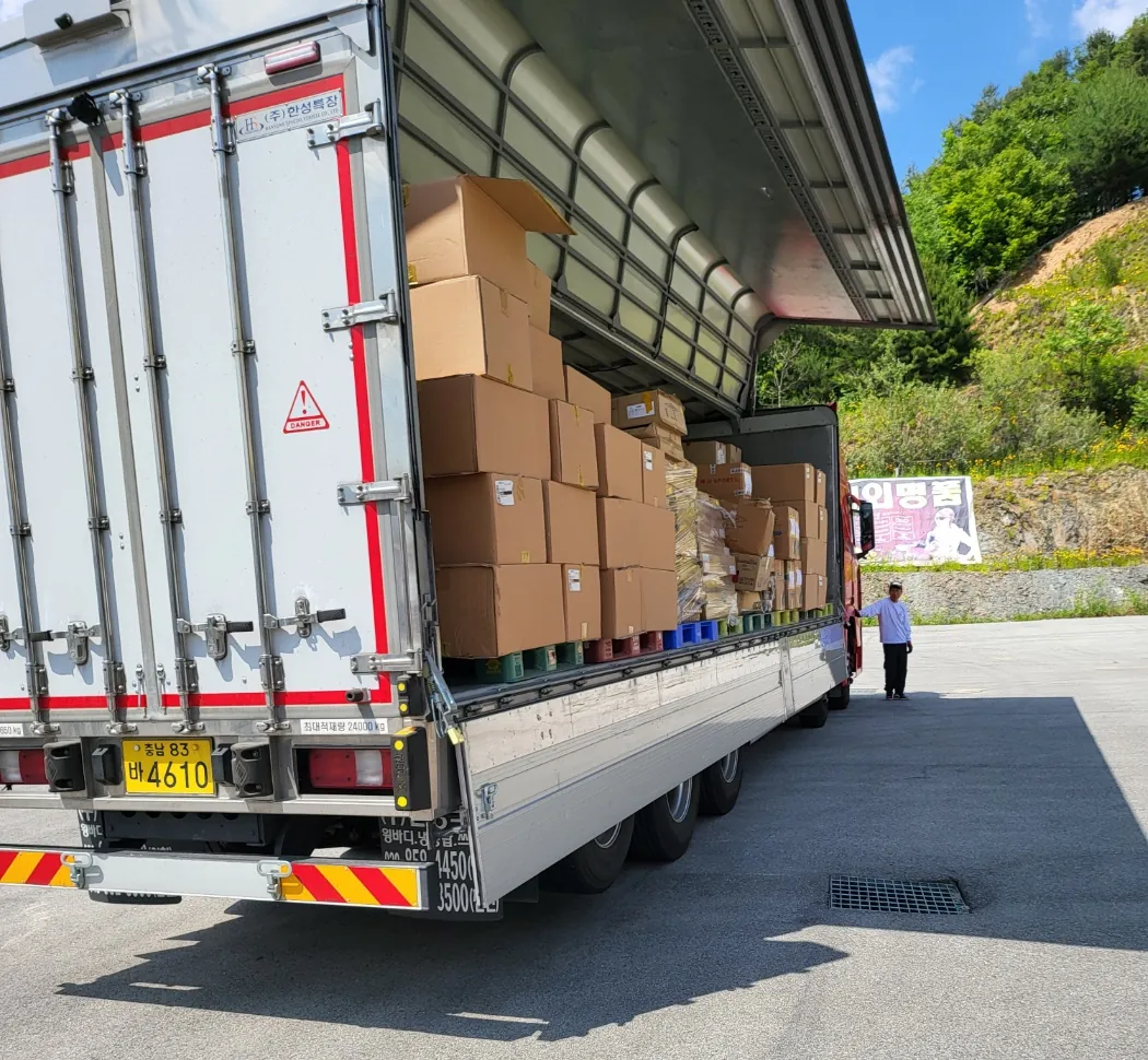 A curtain-side trailer being loaded with palletized cartons